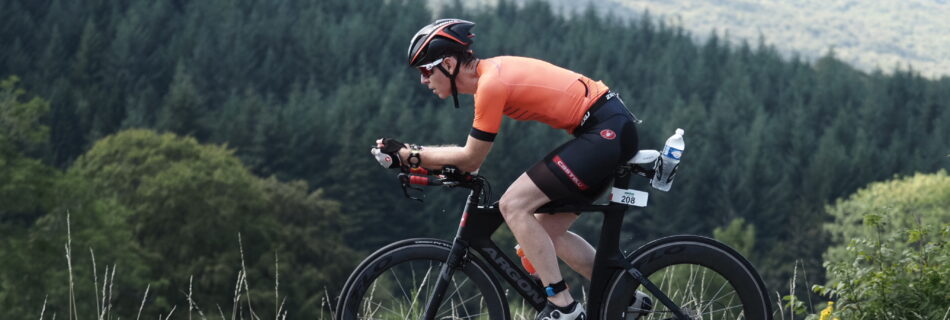 cyclist riding in aero position with forest background